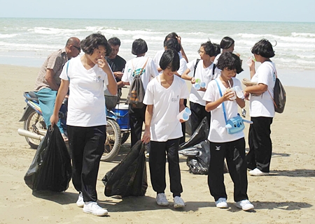 Students from a local school take a water break during their cleanup of Mae Rampung Beach in Rayong.